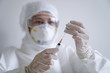 doctor/nurse wearing personal protective equipment and holding syringe of corona/covid-19 vaccine in laboratory/hospital