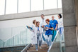 © Halfpoint - Group of doctors walking down stairs on medical conference.