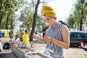 Wall Mural - Young woman at summer festival, washing in the morning.