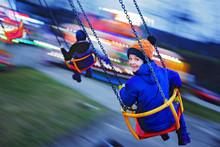 Child, Cute Boy Riding Chain Swing Carousel On Sunset, Motion Blur