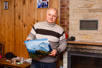 Wall Mural - elderly man holding a photo canvas in a wooden house