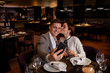 © Roman - young caucasian couple take selfie in restaurant. they have dinner together, take photo of themselves, smile and celebrate anniversary. woman kiss man on cheek. indoors