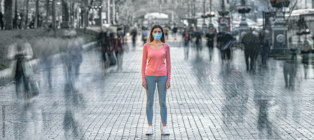 The young woman with medical mask on her face stands on the crowded street - obrazy, fototapety, plakaty 