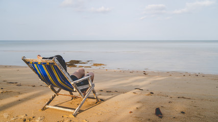 Tourists lying on beds on the beach.