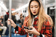 © Eugenio Marongiu - Young asiatic woman travelling underground using smartphone