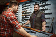 © Nomad_Soul - Man and owner choosing rifle in gun shop