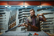 © Nomad_Soul - Man cleans rifle barrel at counter in gun shop
