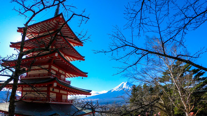 View on Chureito Pagoda and mountain of the mountains Mt Fuji, Japan, captured on a clear, sunny day in winter. Top of the volcano covered with snow. Trees aren't blossoming yet. Postcard from Japan.