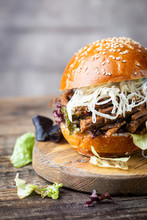 Pulled Beef Burger With Cabbage Salad And Bbq Sauce On Cutting Board