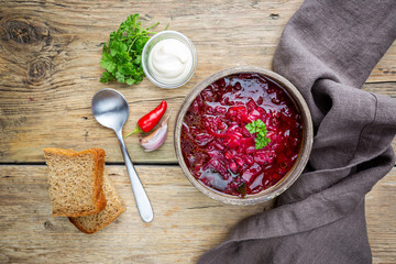 Wall Mural - Traditional Ukrainian Russian vegetable beet soup, borscht on wooden background, top view