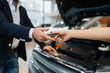 Man and salesgirl choosing auto in car dealership
