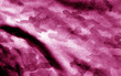 Part of military camouflage uniform close-up with blur effect in pink tone.