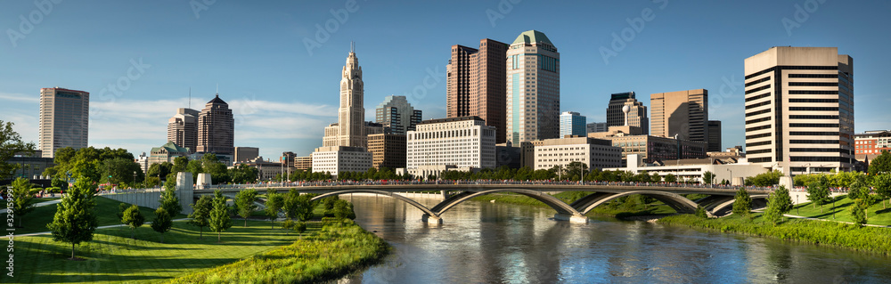 Downtown cityscape panoramic looking over the Scioto River and the Discovery Bridge along the Riverfront Park in the city of Columbus Ohio USA - obrazy, fototapety, plakaty 