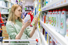 Woman Choosing Detergents In Household Goods Store