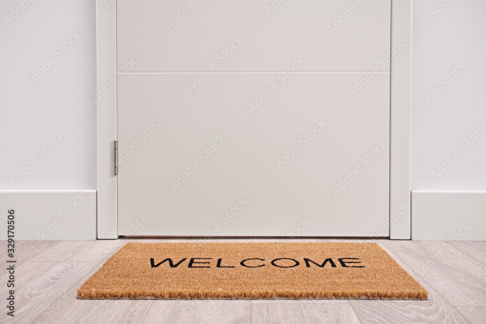White door with a welcome mat - obrazy, fototapety, plakaty 