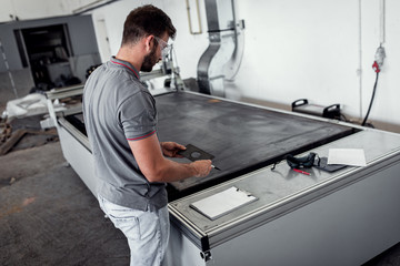 Wall Mural - Young engineer setup plasma cutter for work in metalwork workshop.