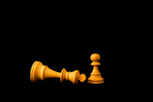 King Surrender To Pawn As The Small And Weak Can Defeat The Big And Powerful Concept. Two Standard Chess Wooden Pieces On Black Background