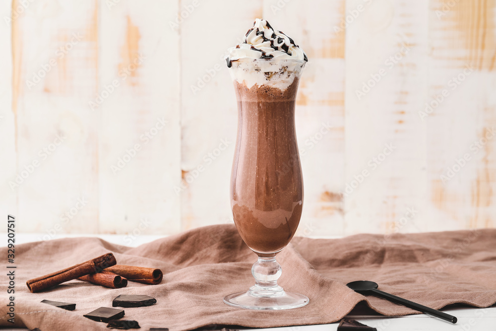 Glass of tasty chocolate milkshake on table