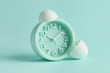 © Pixel-Shot - Alarm clock with broken egg shell on color background