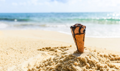 Ice cream cone on sand beach background - Melting ice cream on beach sea in summer hot weather ocean landscape nature outdoor vacation , ice cream chocolate