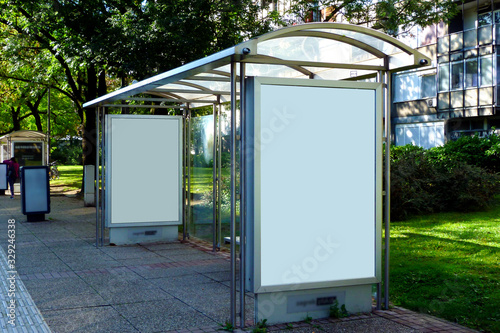 image collage of bus shelter at a bus stop. glass and aluminum frame structure. urban setting with green background. safety glass design. wooden benches. white poster ad display. advertising concept.