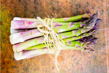 Fresh and raw green asparagus bunch on a vintage background. 