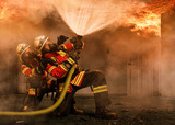 Fototapeta Sport - Feuerwehrmänner unter Atemschutz unter einem Flashover