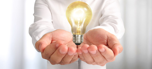 Hand of holding illuminated light bulb. innovation inspiration concept