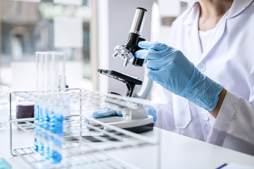 scientist or medical in lab coat working in biotechnological laboratory, microscope equipment for re