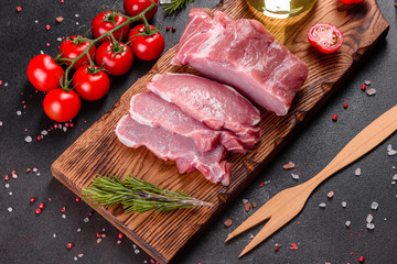 Fresh pieces pork ready to cook on a dark background in the kitchen