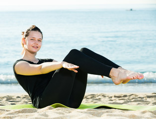 Wall Mural - Healthy girl in black T-shirt is practicing yoga