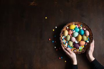  Woman holding a bowl of Easter eggs in her hands. Easter scenery