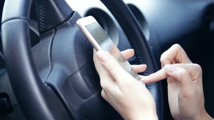 Young woman using smartphone in a car. He is checking mails, chats or the news online. Concept of business, success, traveling