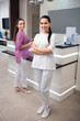 © zinkevych - Cheerful worker of beauty clinic wearing white uniform and sneakers