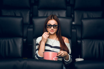 Wall Mural - Young girl in 3D glasses watching movie alone in film theater