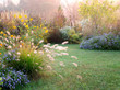 A beautiful fall (autumn) garden that includes flowers, seedheads, and foliage of perennials, grasses, and woody plants, with lawn; copy space