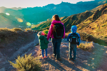 happy family -mother with kids- travel in sunset mountains