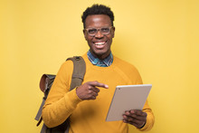 Happy African American College Student Holding Tablet On Isolated Yellow Background