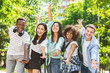 Portrait Of Cheerful Multicultural Students Posing With Raised Hands Outdoors