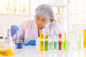 Poster - An Asian female scientist is researching a chemical formula in a lab.