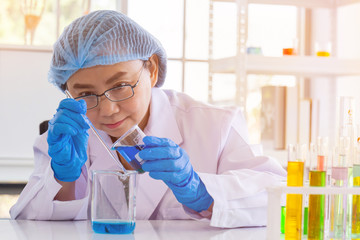 Poster - An Asian female scientist is researching a chemical formula in a lab.