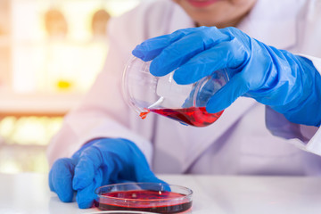 Poster - An Asian female scientist is researching a chemical formula in a lab.