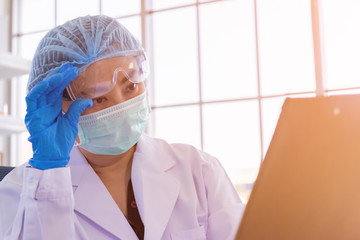 Poster - An Asian female scientist is researching a chemical formula in a lab.