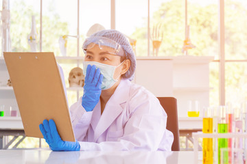 Poster - An Asian female scientist is researching a chemical formula in a lab.