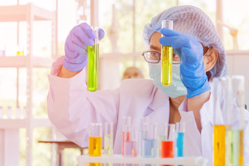 Poster - An Asian female scientist is researching a chemical formula in a lab.