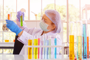Poster - An Asian female scientist is researching a chemical formula in a lab.