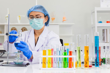 Poster - An Asian female scientist is researching a chemical formula in a lab.