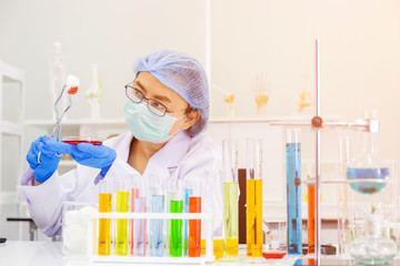 Poster - An Asian female scientist is researching a chemical formula in a lab.