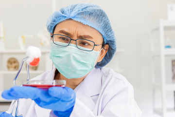 Poster - An Asian female scientist is researching a chemical formula in a lab.