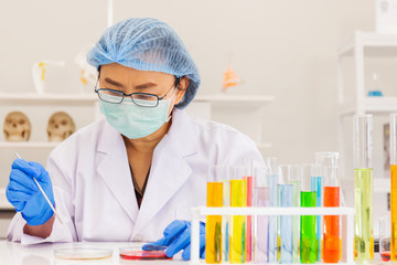 Poster - An Asian female scientist is researching a chemical formula in a lab.